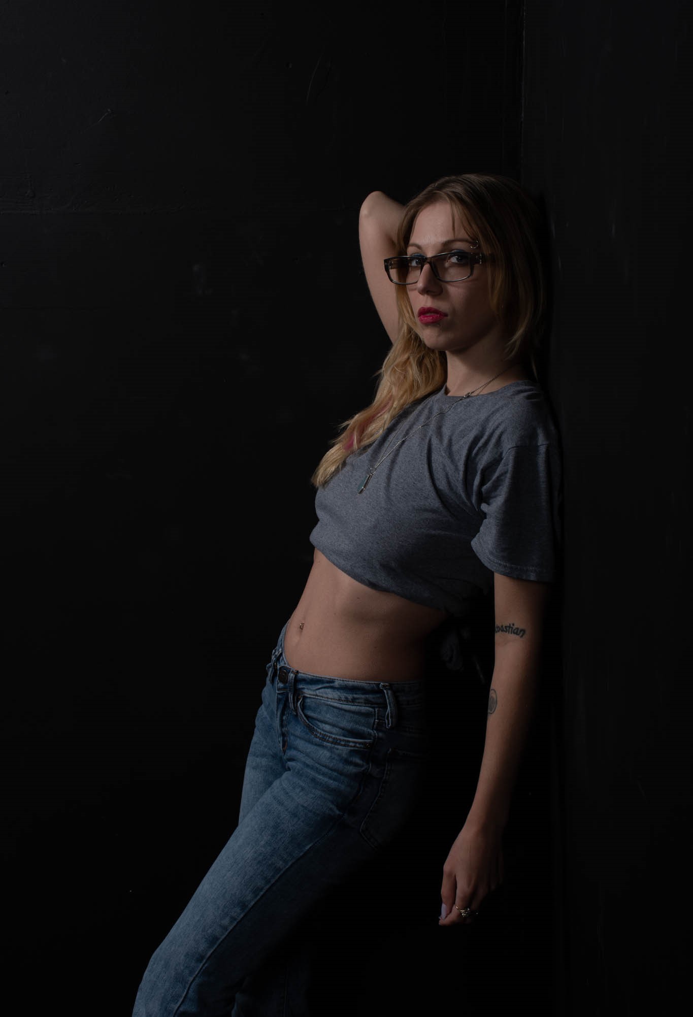 Model leaning against black wall